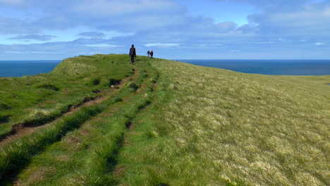 Wandernde-Menschen-Auf-Wunderschönen,-Grünen-Klippen-Im-Vorgebirge-Latrabjarg-über-Dem-Atlantischen-Ozean-In-Den-Westfjorden-Islands-–-Dem-Westlichsten-Punkt-Islands