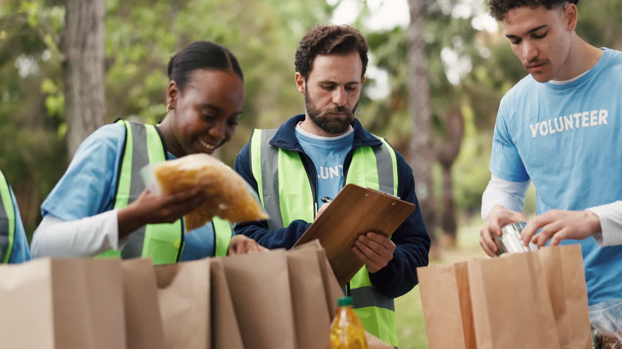 Bénévoles diversifiés emballant des dons alimentaires dans des sacs en extérieur