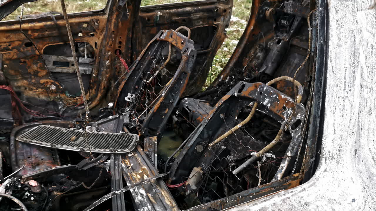 Close-up of burnt car seats with exposed springs and ash