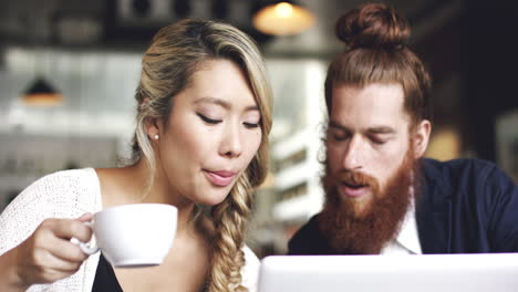 young couple using digital tablet computer in cafe