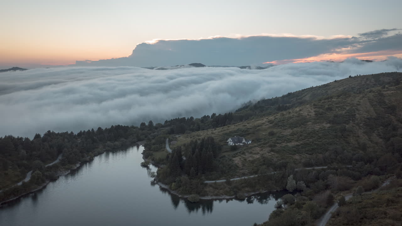 Lago di Giacopiane ved soloppgang, med tåke som dekker de omkringliggende åsene, flyfoto
