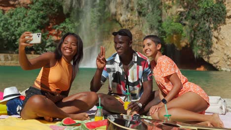 Carefree-diverse-guy-and-women-taking-selfie-on-sunny-beach