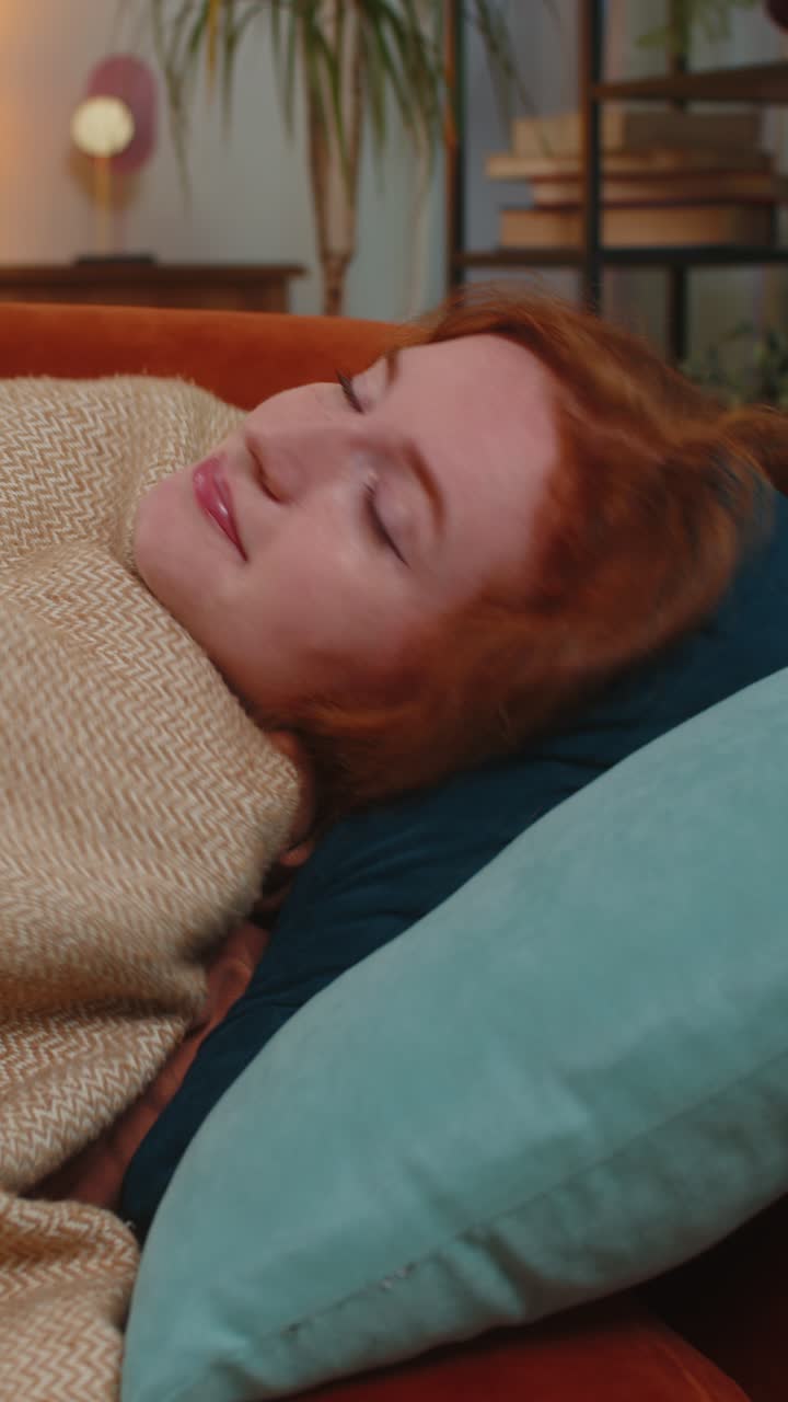 mujer se despierta repentinamente de una pesadilla mientras duerme en el sofá debido a un trastorno de ansiedad malos sueños