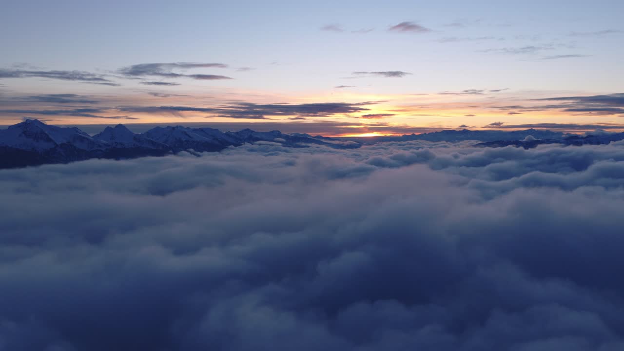 Snow-covered Mountain Peaks Emerging Above A Sea Of Clouds In Catena del Lagorai, Val di Fiemme, Italy. - aerial shot