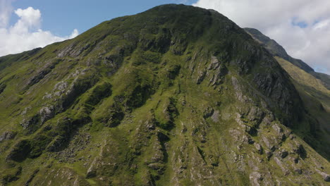 aerial view climbing up the mountain to reveal the mountain range, shot in 4k in the irish countryside