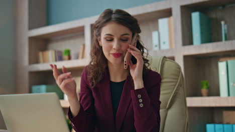 smiling manager calling smartphone at workplace closeup. happy woman consulting