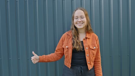 Happy-positive-Danish-girl-in-casual-orange-pointing-towards-a-product-placement