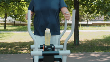 hombre con sobrepeso haciendo ejercicio en una máquina de caminar en el parque