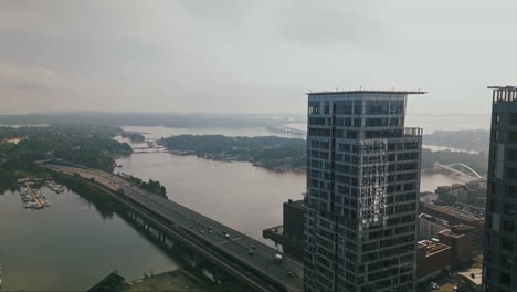 Flying-past-Redi-towers-complex-skyscraper-towards-the-archipelago-landscape-in-Kalasatama,-Helsinki