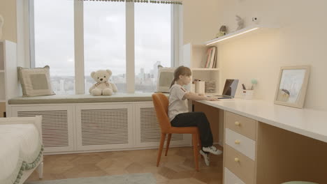 girl studying in her cozy bedroom with city view