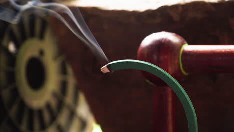 Incense-stick-burning-with-smoke,-close-up,-Phi-Phi,-Thailand