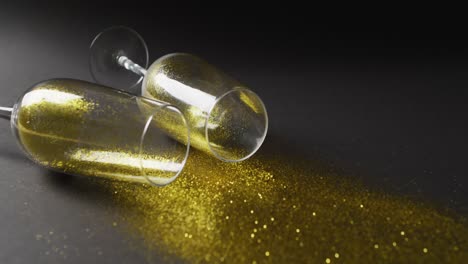 video de dos copas de champán con brillo dorado sobre fondo negro