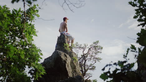 picnic pacífico en la cima de la montaña, hombre tomando un descanso en el campo de flores, torre de piedra, disfrutando de la vista, disfrutando de la vista, vista general del paisaje, cámara lenta cinematográfica slomo, hombre disfruta de las colinas al aire libre