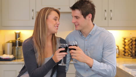 couple sitting in the kitchen drinking wine