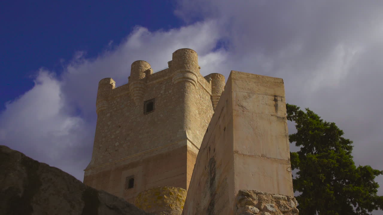 Low angle time-lapse view of The Atalaya Castle where clouds are moving under the blue sky, Villena, Province of Alicante, southern Spain.