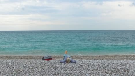 woman relaxing on a pebble beach