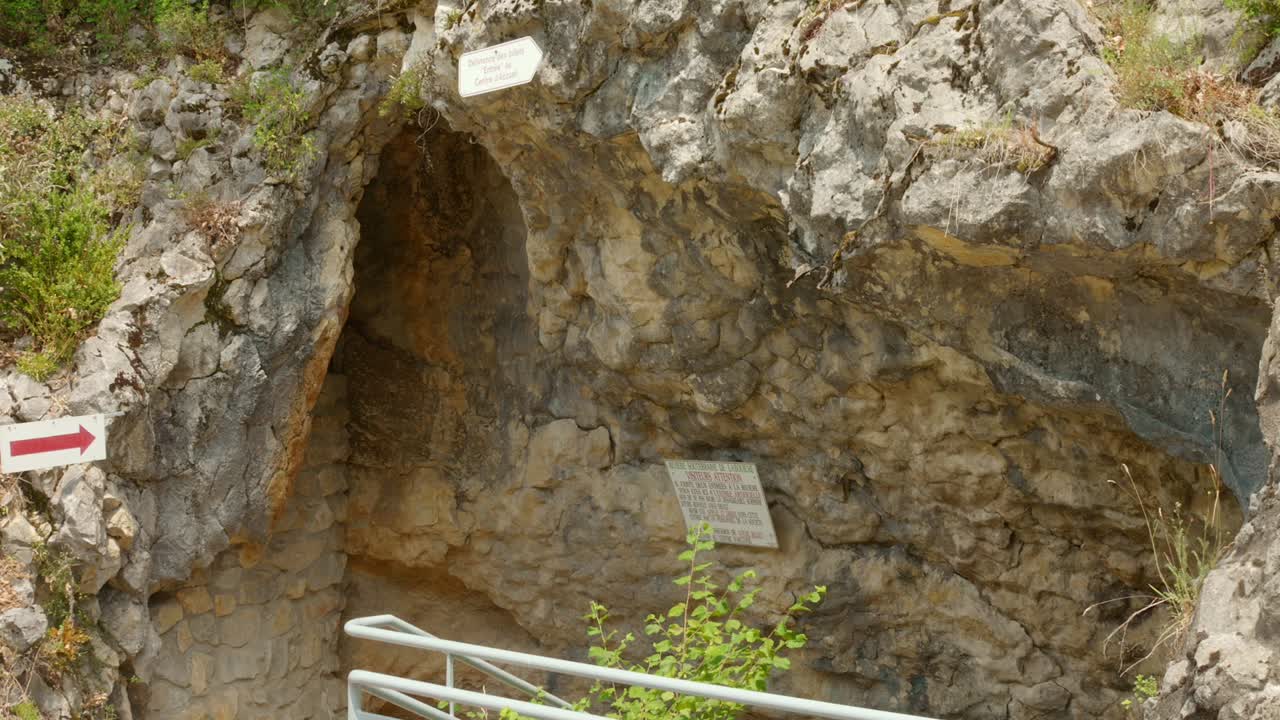 Explore the enchanting entrance of Labouiche Underground River, nestled in stunning rock formations. Discover this captivating location through dynamic angles and lush greenery surrounding the site