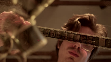 person inspecting a vintage film strip