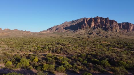 caminos de tierra en el paisaje desértico que conducen a la cordillera durante la puesta de sol en arizona