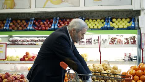hombre maduro comprando frutas frescas en el supermercado