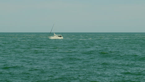 un velero solitario se desliza en el mar abierto bajo un cielo despejado