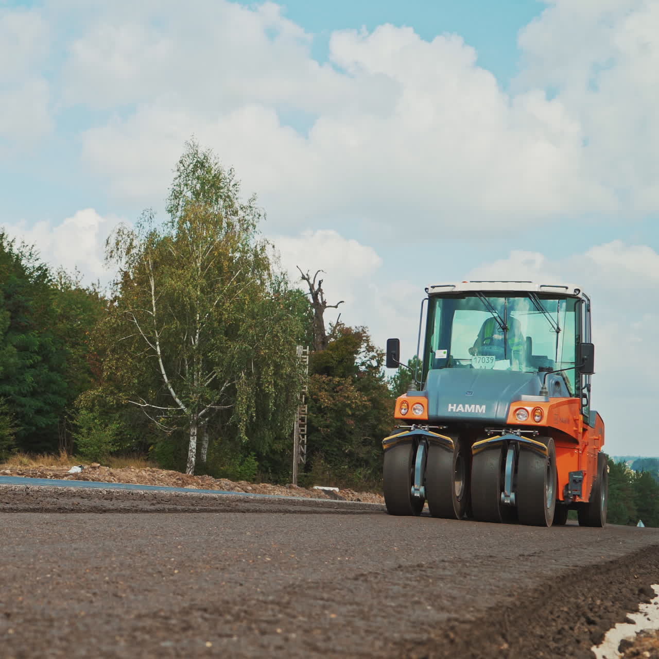 Heavy asphalt roller that stack and press hot asphalt. Road repair machine. Repairing in modern city with vibration roller compactor