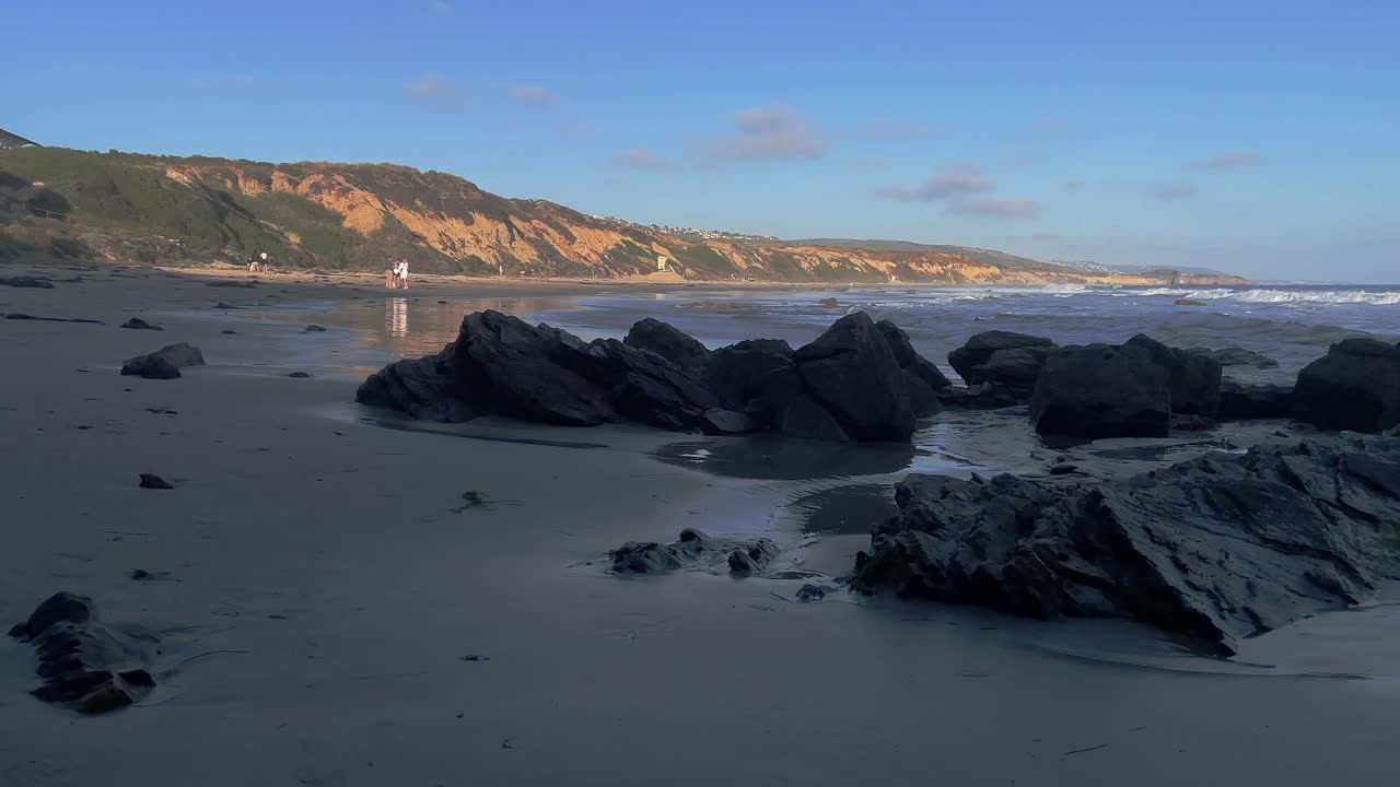 playa corona del mar con vista estática de las rocas con acantilados y pequeñas olas del océano pacífico en la parte posterior