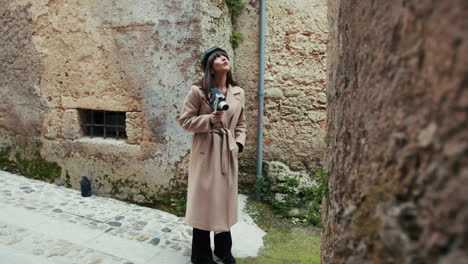 woman with a vintage camera looking around the old town streets for inspiration