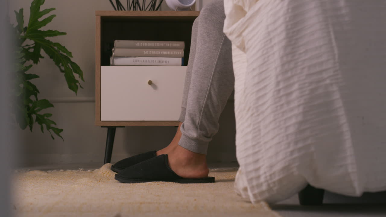 Bedroom scene with slippers and nightstand