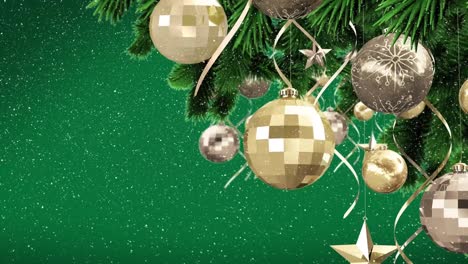 Animation-of-snow-falling-over-christmas-baubles-on-tree-on-green-background