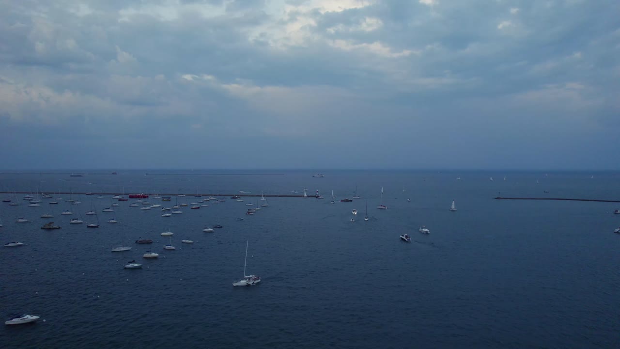 Aerial view of dozens of boats anchored on Lake Michigan under a cloudy sky near Chicago’s waterfront. Peaceful and expansive.