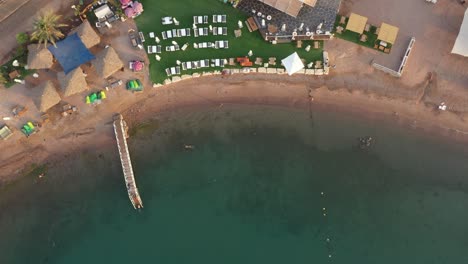 playa impecablemente limpia con tiendas de campaña hierba y sombra en el desierto con coral bajo el agua y muelle para nadadores en el mar rojo, eilat, antena de israel