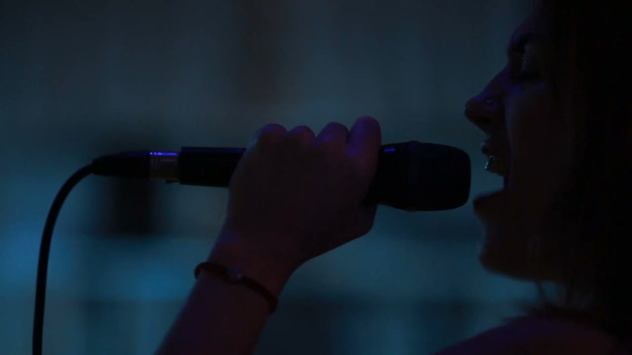 Cantante donna con un microfono. Una cantante donna con un microfono in mano canta sul palco.