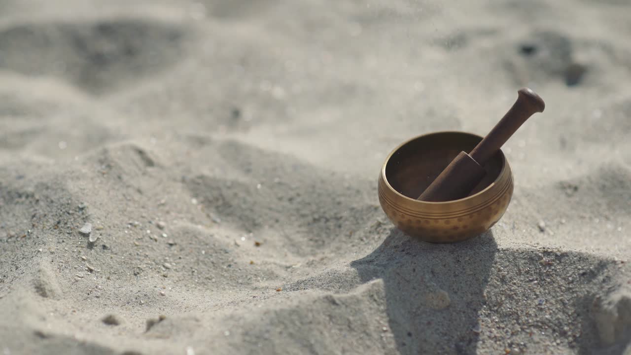cuenco de canto tibetano de bronce para la meditación en la playa de mar de arena