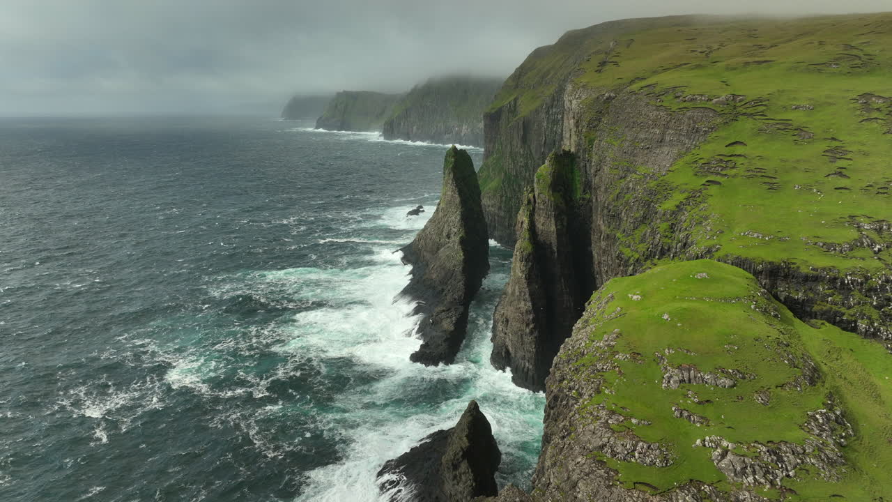 Geituskoradrangur Sea Stack in Atlantic Ocean Faroe Islands AERIAL PULLBACK