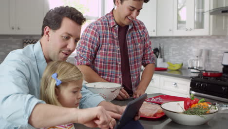 Girl-using-tablet-in-kitchen-with-male-parents,-close-up,-shot-on-R3D