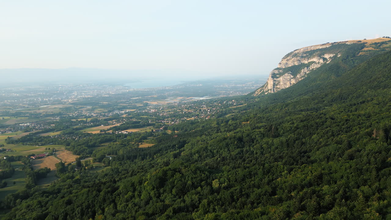 Aerial: Saleve, canton of Geneva and Lake of Geneva at sunset from France, establishing drone shot