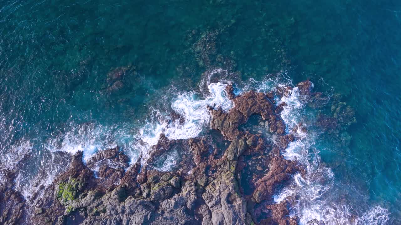 Vista aerea delle onde oceaniche che si infrangono sulla costa rocciosa, scena rilassante