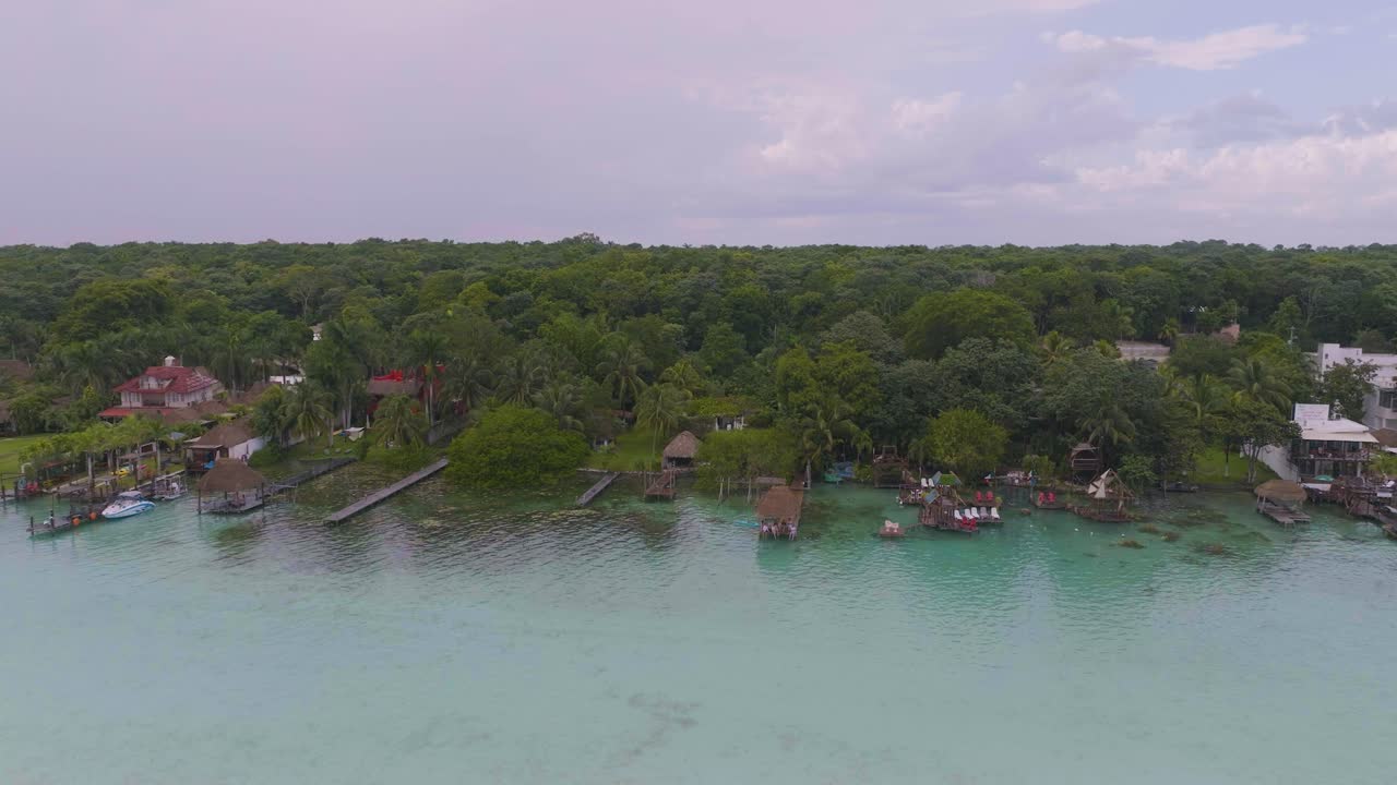 villas de bungalows sobre el agua en el bacalar tropical, costa de méxico - vista aérea al atardecer
