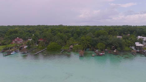 Villas-De-Bungalows-Sobre-El-Agua-En-Bacalar-Tropical,-Costa-De-México---Antena-Al-Atardecer