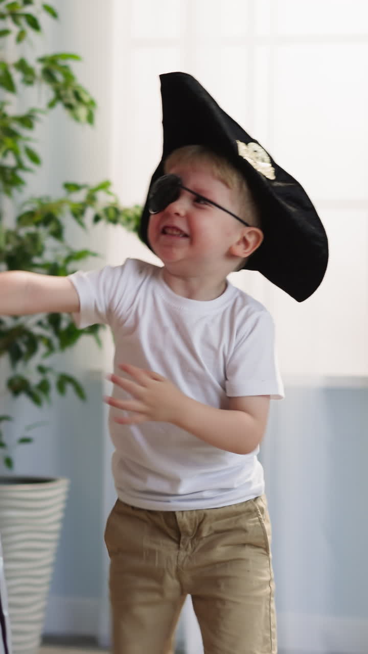 niño pequeño con sombrero de pirata y parche en el ojo ataca a la hermana mayor con una espada de juguete juguetón. niños felices hermanos juegan a duelo corriendo por la habitación y haciendo ruido