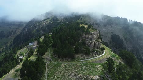 drone zoom in over a lush mountain ridge partially covered by fog in valle de ip, aragon, spain