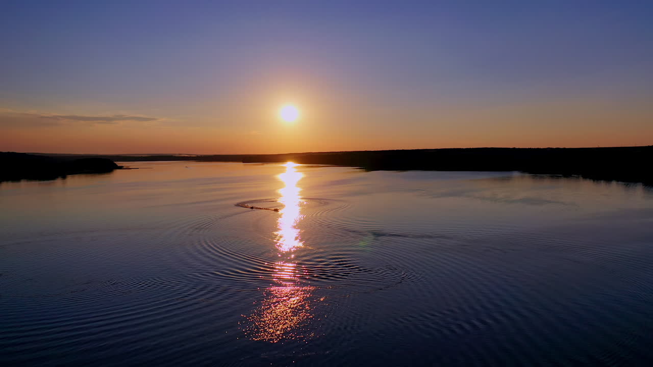 Beautiful sunset in nature. Sunny path reflects on the river in the evening. Amazing view on the lake against the setting sun.