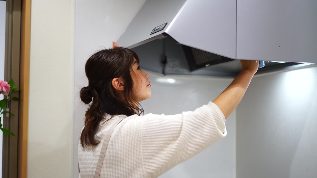 mujer limpiando el ventilador