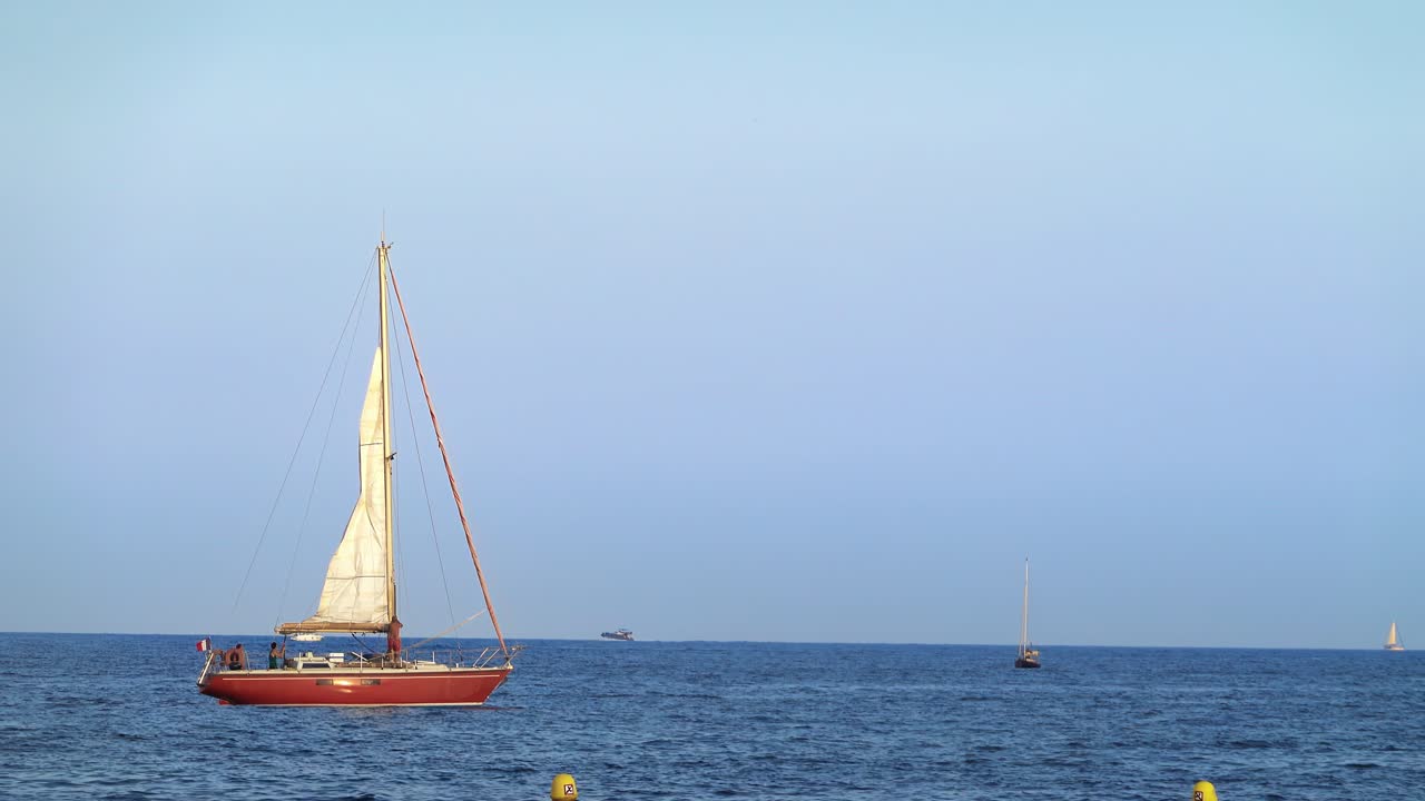 People on a moving, orange boat on the sea in France