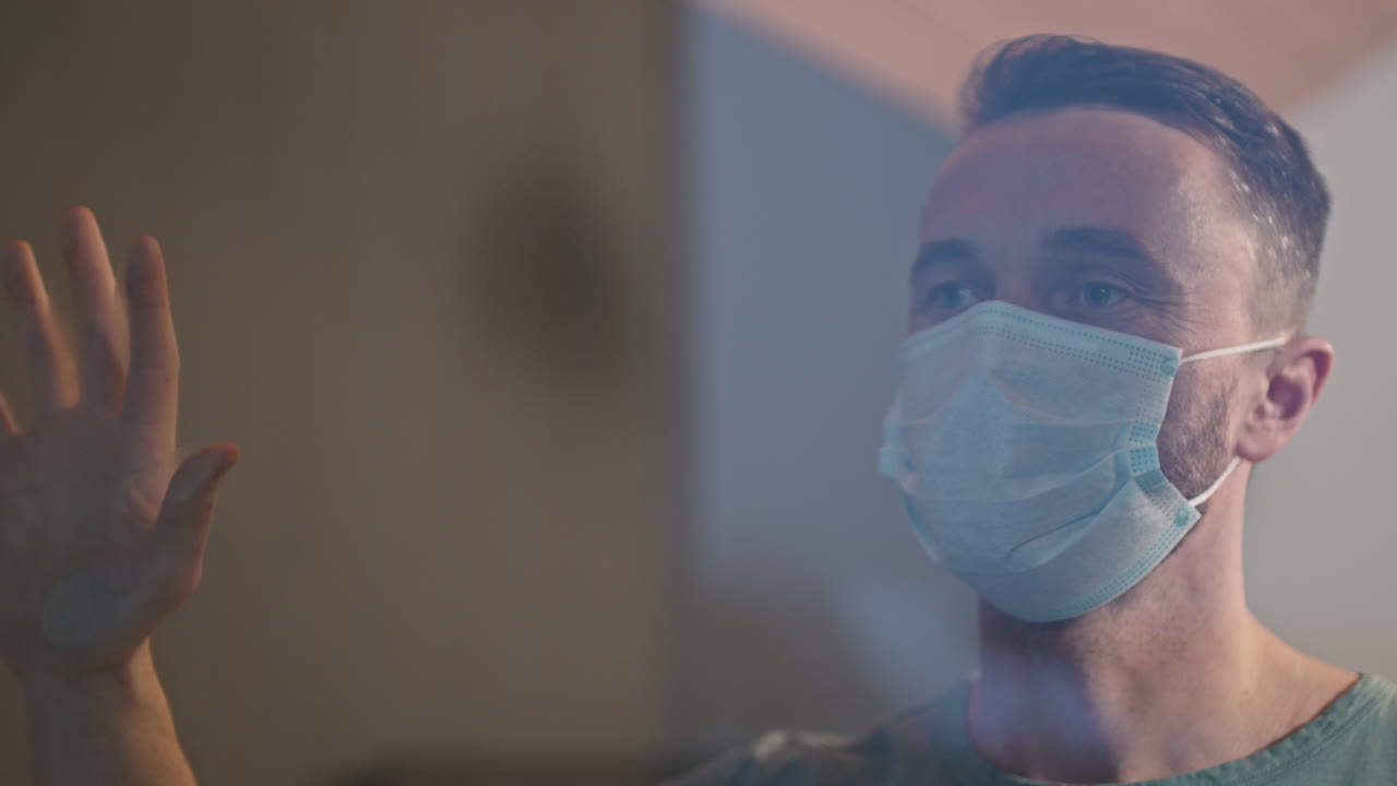 Caucasian Man In Face Mask Standing Near Window