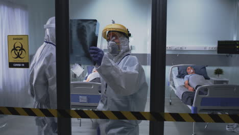 hospital staff examining x-ray in a covid-19 ward
