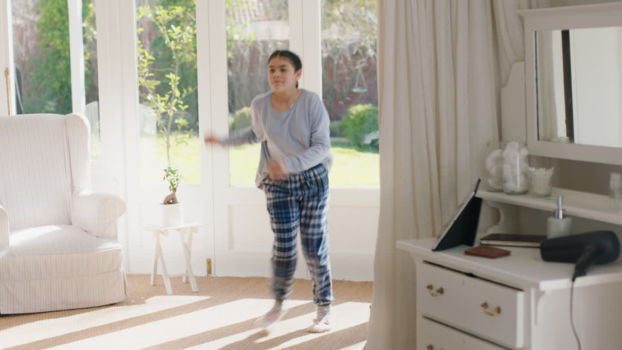 행복한 십대 소녀가 침실에서 음악에 맞춰 춤을 추고 주말 아침을 즐기고 즐겁게 축하하고 집에서 피자마를 입고 무관심한 생활 방식을 즐기고