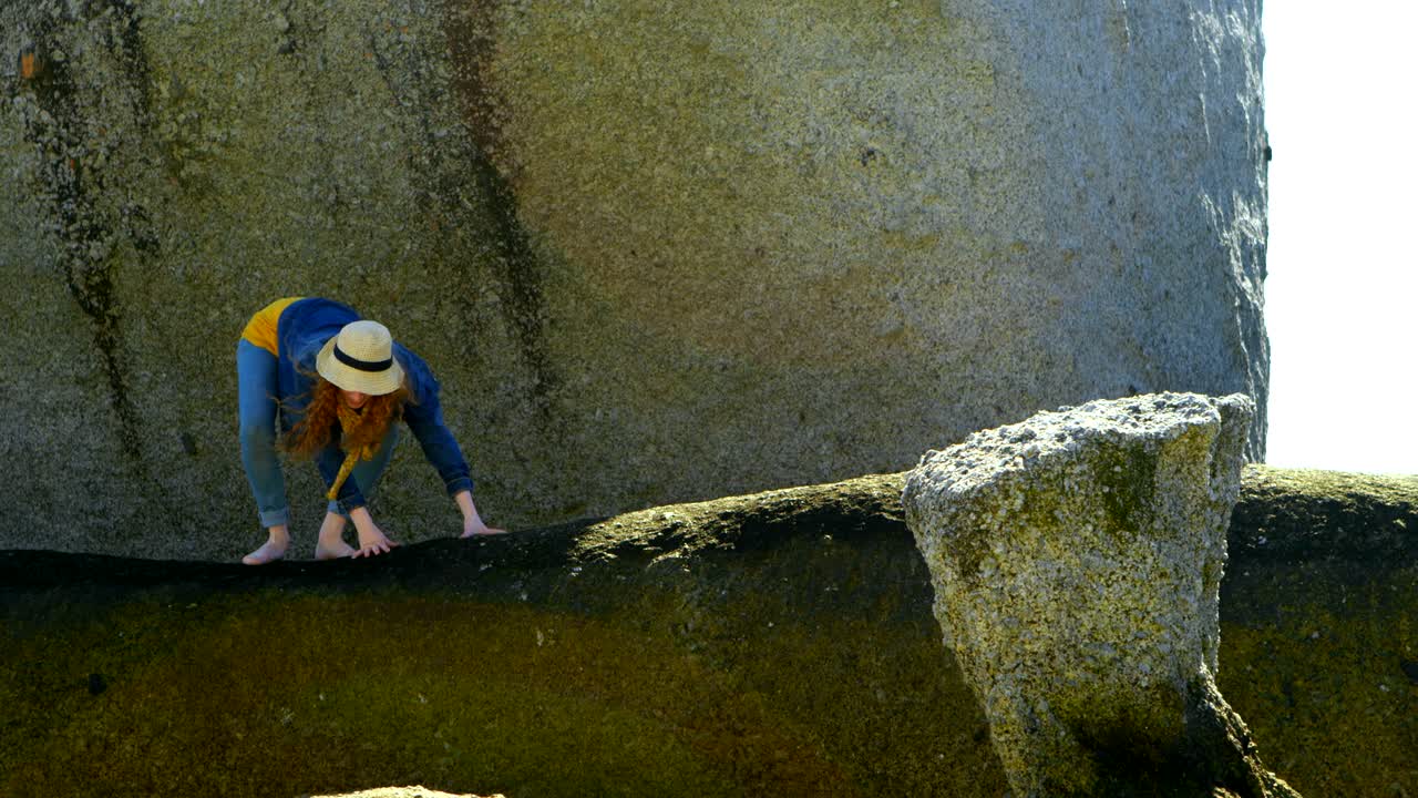해변 4k에 있는 바위 위에 서 있는 여자