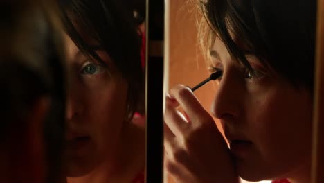 dark moody clip of beautiful young early 20s or 30s women lady girl putting mascara makeup on eyes in split mirror bathroom cinematic close shot